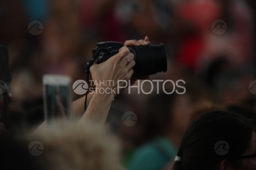 Mains portant un appareil photo, prenant des clichés, en public