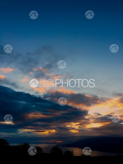 Coucher de soleil sur Tahiti, quartier de lune haut dans le ciel