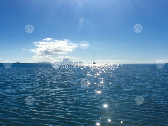 Catamaran ancré dans la lagune de Tahaa, Bora Bora en arrière plan