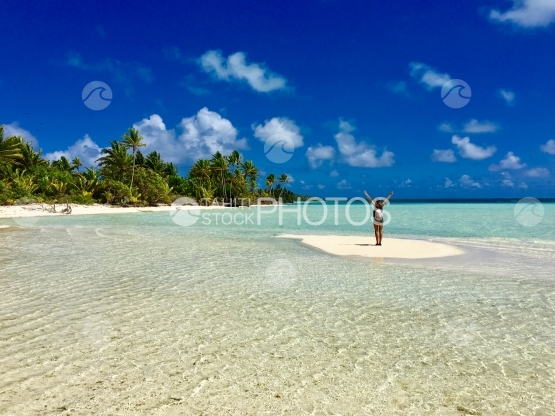 Jeune femme levant les bras, sur la plage, lagon de Tetiaroa