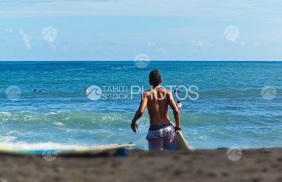 Tahiti, jeune allant surfer les vagues