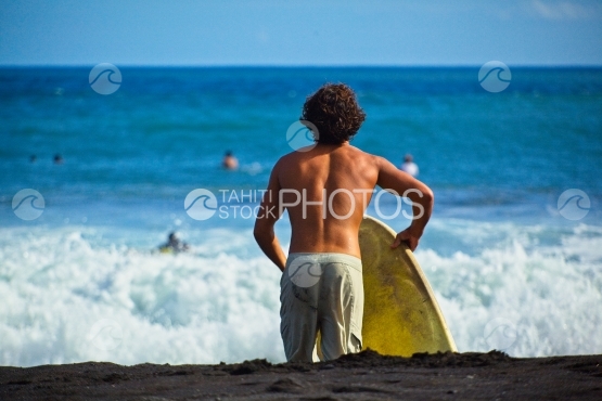 Tahiti, jeune allant surfer les vagues