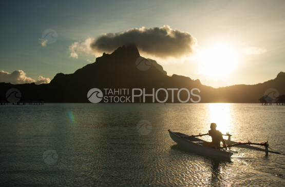 Polynésien sur sa pirogue, ramant sur le lagon de Bora Bora