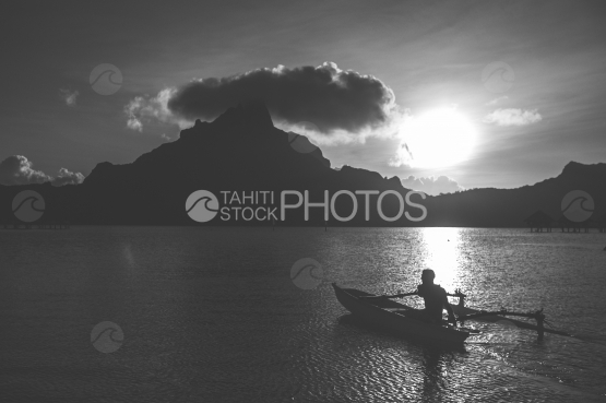 Polynésien sur sa pirogue, ramant sur le lagon de Bora Bora, noir et blanc