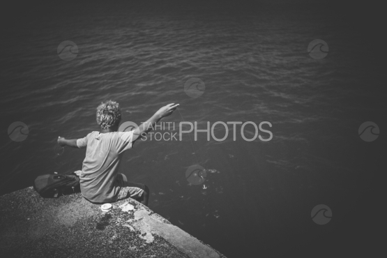 Jeune polynésien pêchant près du bord de mer
