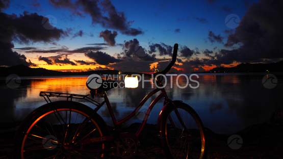 Vélo laissé près du lagon de Bora bora au coucher de soleil  