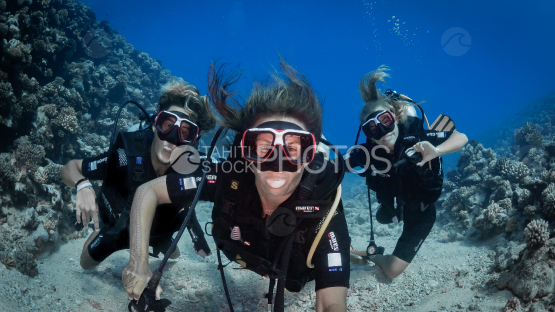 Happy Family diving by the coral reef, Moorea